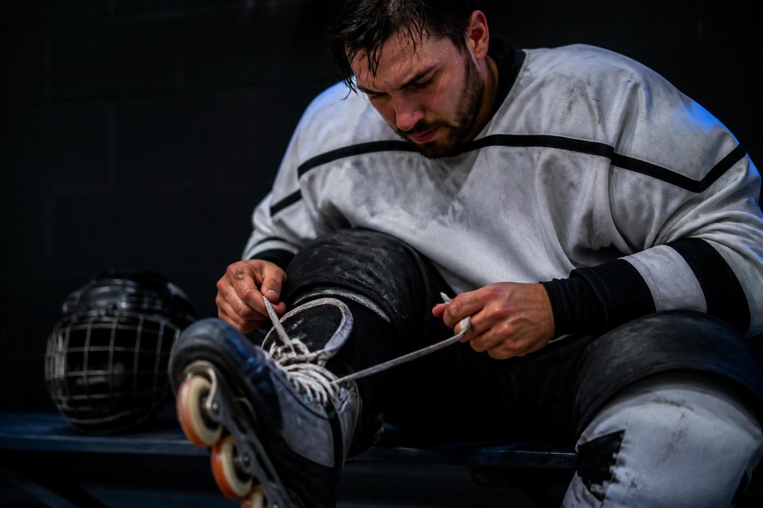 A player lacing up skates before a game